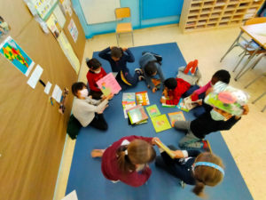 nens i nenes llegint i ensenyant llibres