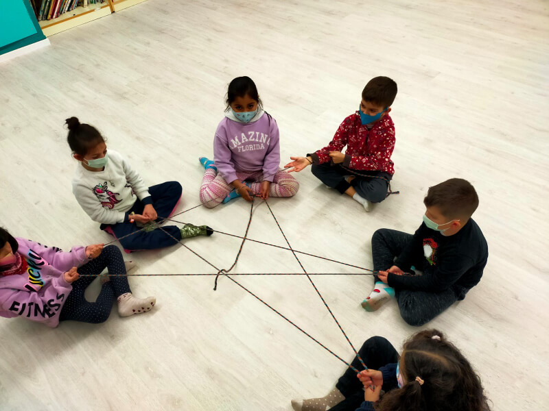nens i nenes fent la figura d'una estrella amb corda